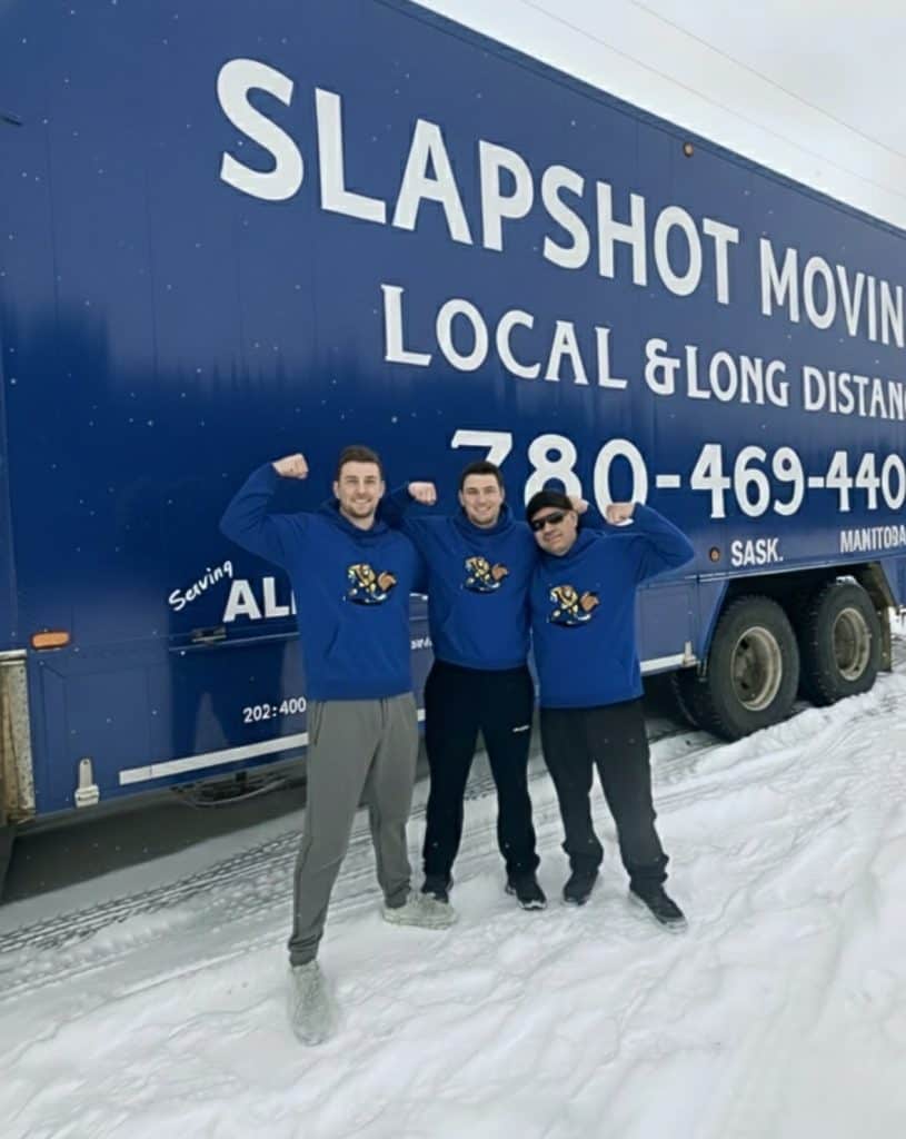 Professional moving team in front of Slapshot Moving truck, ready for local and long-distance moves.